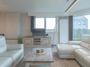 a living room with a couch and a tv at De Golfbreker in Middelkerke