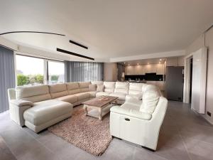 a living room with a white couch and a table at De Golfbreker in Middelkerke