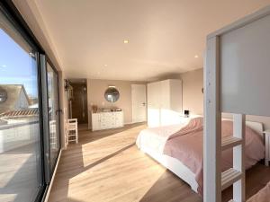 a bedroom with a bed and a large window at De Golfbreker in Middelkerke
