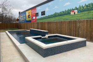 a swimming pool in front of a wooden fence at Downtown 2-Story Home with Enclosed Backyard, Patio, Pool, Playground, W/D, AC in Fredericksburg