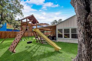 a playground with a slide in a yard at Downtown 2-Story Home with Enclosed Backyard, Patio, Pool, Playground, W/D, AC in Fredericksburg