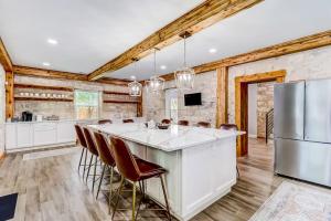 a kitchen with a large island with a refrigerator at Downtown 2-Story Home with Enclosed Backyard, Patio, Pool, Playground, W/D, AC in Fredericksburg