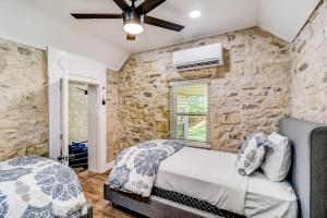 a bedroom with a bed and a stone wall at Downtown 2-Story Home with Enclosed Backyard, Patio, Pool, Playground, W/D, AC in Fredericksburg +30 photos