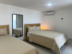 a bedroom with two beds and a mirror at Santa Barbara River house in Santo Domingo