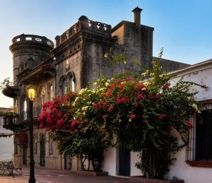 an old building with flowers in front of it at Santa Barbara River house in Santo Domingo