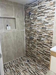 a bathroom with a shower with a stone wall at Santa Barbara River house in Santo Domingo +25 photos