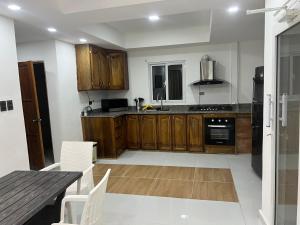 a kitchen with wooden cabinets and a table with chairs at Santa Barbara River house in Santo Domingo