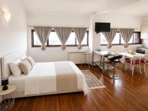 a bedroom with a white bed and a kitchen at Sweets Suites Espinho in Espinho