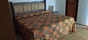 a bedroom with a bed with a quilt on it at HOTEL PARAISO ESCONDIDO in Chacala