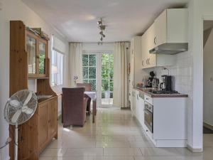 a kitchen with white appliances and a table with a fan at Spijk vakantiehuis in Spijk
