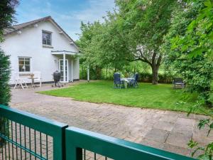 a white house with a yard with chairs at Spijk vakantiehuis in Spijk