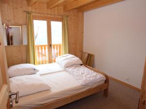 ラ・ズマにあるNice Holiday Home in Riddes with Saunaのベッドルーム1室(大型ベッド1台、窓付)