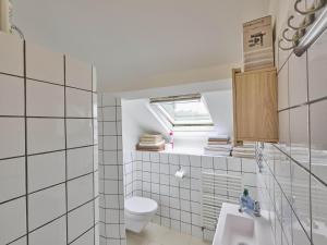 a bathroom with a toilet and a sink and a window at Spijk vakantiehuis in Spijk +27 photos