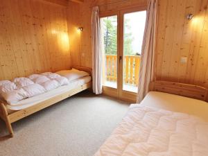 ラ・ズマにあるNice Holiday Home in Riddes with Saunaのベッドルーム1室(ベッド2台、窓付)
