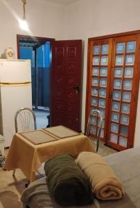 a room with two beds and two chairs and doors at Microcasa Pousada Residencial Botânica com Kit Café da manhã in Itupeva