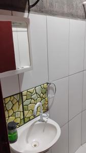 a bathroom with a sink and a mirror at Microcasa Pousada Residencial Botânica com Kit Café da manhã in Itupeva