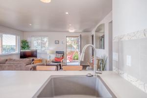 a kitchen with a sink and a living room at Sandy Feet in Nehalem +21 photos
