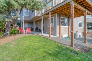 a house with a porch with red chairs on a yard at Sandy Feet in Nehalem