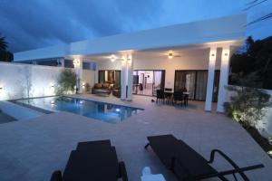 a villa with a swimming pool at night at AVANA Villa in Nathon Bay