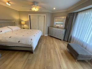a bedroom with a bed and a dresser and a mirror at View of Ocean & MOUNT BAKER in White Rock