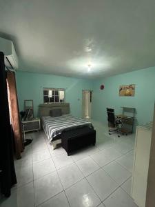 a bedroom with a bed and a chair in it at Ricardo's Rest Spot in Curatoe Hill