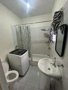 a white bathroom with a toilet and a sink at Ricardo's Rest Spot in Curatoe Hill +24 photos