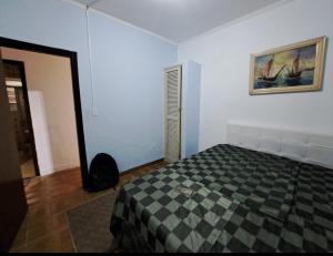 a bedroom with a bed and a picture on the wall at Pousada Praia Grande in Mongaguá