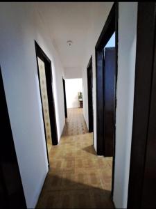 a hallway of an empty room with doors and a tile floor at Pousada Praia Grande in Mongaguá
