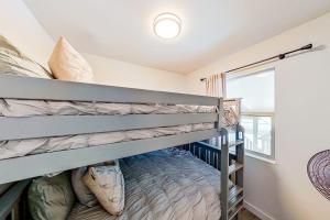 a bedroom with two bunk beds and a window at Contemporary, Dog-Friendly Townhouse with Balcony, Pool & Day Docks in Horseshoe Bay