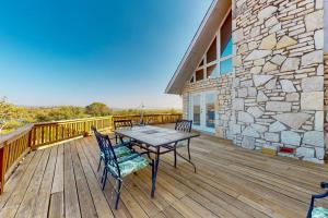 a wooden deck with a table and chairs on it at Lovely 2-Story Home with Upper & Lower Decks, Gorgeous Lake & Hill Country Views in Burnet