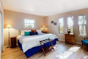 a bedroom with a large bed and two windows at Lovely 2-Story Home with Upper & Lower Decks, Gorgeous Lake & Hill Country Views in Burnet