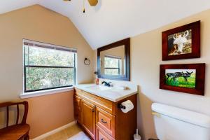 a bathroom with a sink and a toilet and a window at Lovely 2-Story Home with Upper & Lower Decks, Gorgeous Lake & Hill Country Views in Burnet +22 photos