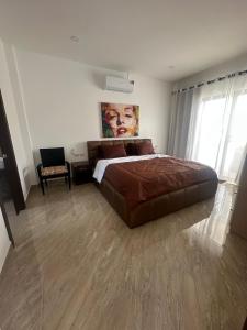 a bedroom with a large bed and a chair at AVANA Villa in Nathon Bay