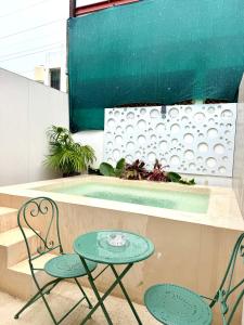 two chairs and a table and a table and chairs at Sakna Mérida con jacuzzi alberca privada in Mérida