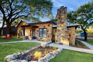 a stone house with a stone chimney in a yard at Blue Haus with Hot Tub, Shuffleboard, EV Charger - Walk to Town & Wineries in Johnson City