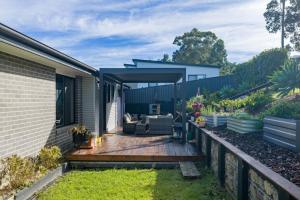 a backyard with a wooden deck with a couch at Marlin Vista - Pet Friendly in Eden