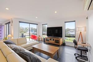 a living room with a couch and a flat screen tv at Marlin Vista - Pet Friendly in Eden +6 photos