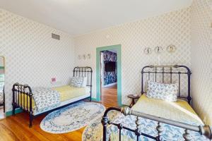 a bedroom with two beds and a mirror at Blue Haus with Hot Tub, Shuffleboard, EV Charger - Walk to Town & Wineries in Johnson City