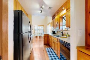 a kitchen with a stainless steel refrigerator and wooden cabinets at Peaceful Home with Fire Pit, Gazebo, Patio, & Amazing Deck Views - Dog-Friendly in Fredericksburg