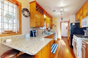 a kitchen with wooden cabinets and a counter top at Peaceful Home with Fire Pit, Gazebo, Patio, & Amazing Deck Views - Dog-Friendly in Fredericksburg