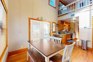 a dining room with a wooden table and white chairs at Peaceful Home with Fire Pit, Gazebo, Patio, & Amazing Deck Views - Dog-Friendly in Fredericksburg