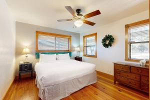 a bedroom with a white bed and a ceiling fan at Peaceful Home with Fire Pit, Gazebo, Patio, & Amazing Deck Views - Dog-Friendly in Fredericksburg +16 photos