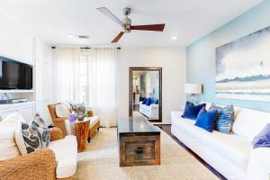 a living room with white furniture and a ceiling fan at Water-View Condo with Balcony, Smart TVs, Washer/Dryer and Pool in Horseshoe Bay