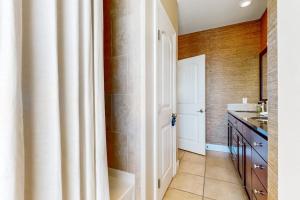 a bathroom with a sink and a white door at Water-View Condo with Balcony, Smart TVs, Washer/Dryer and Pool in Horseshoe Bay +17 photos