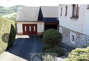 a house with a red door and a stone wall at Byty Na vyhlídce in Zdice