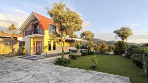 ein Haus mit orangefarbenem Dach und einem Garten in der Unterkunft BTMINDAHaa in Setengh