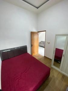 ein Schlafzimmer mit einem großen roten Bett und einem Spiegel in der Unterkunft BTMINDAHaa in Setengh