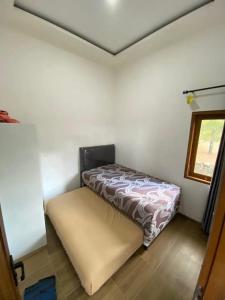 ein kleines Schlafzimmer mit einem Bett in der Ecke in der Unterkunft BTMINDAHaa in Setengh + 6 Fotos