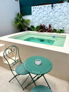 a table and chairs next to a swimming pool at Sakna Mérida con jacuzzi alberca privada in Mérida
