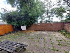 a backyard with a brick wall and a bench at Lindi Property Double Room with Garden View in Wyken